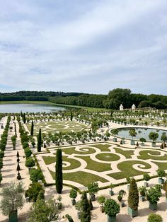 an elaborate garden is shown in the middle of a field with trees and bushes around it