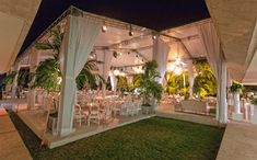 an outdoor wedding venue with white linens and greenery