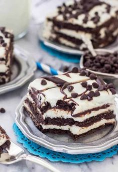 chocolate cake with white frosting and chocolate chips on the side, surrounded by other desserts