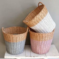 three wicker baskets sitting on top of a shelf