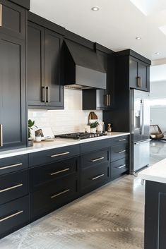 a kitchen with black cabinets and white counter tops