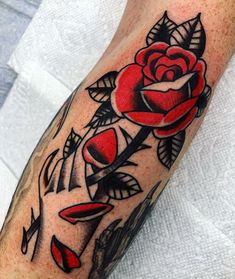 a rose tattoo on the left arm and leg, with red roses in it's center