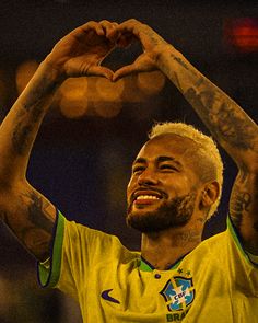 a man making a heart shape with his hands while standing in front of a crowd