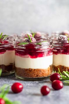 small jars filled with cheesecakes and cranberries on top of a table