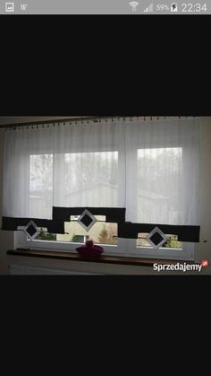 a living room filled with furniture and windows covered in white sheer curtaines on top of a window sill