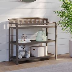 a baby crib next to a potted plant and stuffed animal on the floor