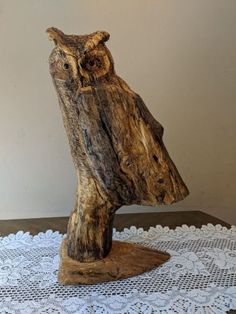 an owl figurine sitting on top of a doily next to a wall