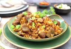 a green plate topped with rice and meat