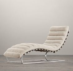 a modern chaise lounge chair in an empty room