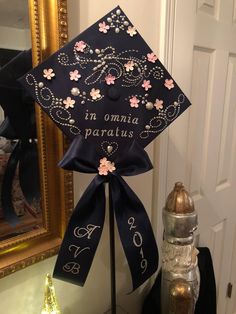 a decorated graduation cap on top of a stand in front of a mirror and other items