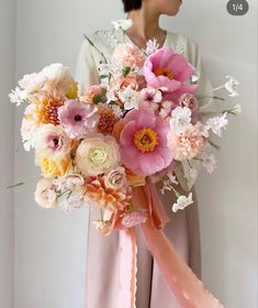 a woman holding a bouquet of flowers in her hands