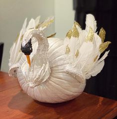 a white swan sculpture sitting on top of a wooden table