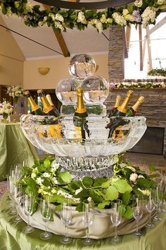 there is a large glass platter with wine bottles on it and glasses in the center