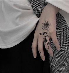 a woman's hand with a flower tattoo on it