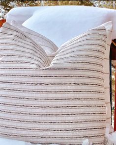 a pillow sitting on top of a chair covered in snow