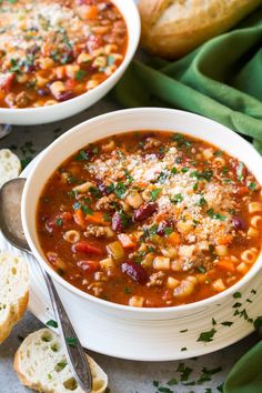 two bowls of soup with bread on the side