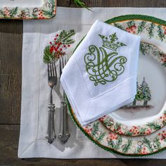 a place setting with christmas napkins and silverware