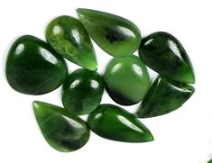 green sea glass pebbles on a white background