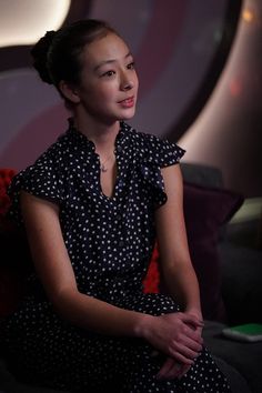 a woman in a polka dot dress sitting on a couch