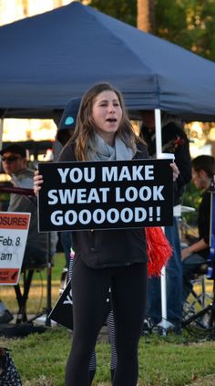 a woman holding a sign that says you make sweat look good