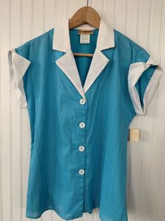 "NEW with original tags! Vintage Bright Blue and white Sleeveless Top with button down closure. White collar and sleeve trim. Size Medium. Authentic vintage deadstock from the early 80s, New With Tags! Brand - Illusions of California 60% Cotton 40% Polyester Machine Washable Condition - Original Deadstock from the 80s, New With Tags Vintage Size - Medium Fits Like - Medium (see measurements) Measurements (Seam to seam, lying flat) - Bust* - 40\" Waist* - 38\" Length - 26\" Sleeve (from collar) - Retro Blue Sleeveless Top, Retro Daywear Top With Button Closure, Blue Retro Tops With Buttons, Retro Tops With Button Closure For Daywear, Retro Top With Button Closure For Daywear, Retro Blue Collared Blouse, Retro Blue Blouse With Buttons, Retro Sleeveless Cotton Blouse, Vintage Sleeveless Tops With Button Closure