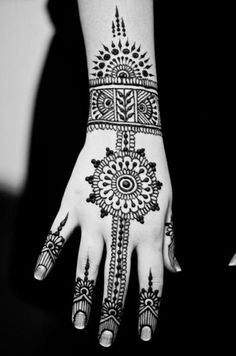 a woman's hand with henna tattoos on it