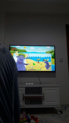 a person standing in front of a flat screen tv with monsters on it's screen