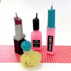 three different types of nail polish on a pink and white checkered tablecloth with an empty bottle next to it