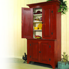 a wooden cabinet with two doors and shelves on the bottom, next to a potted plant