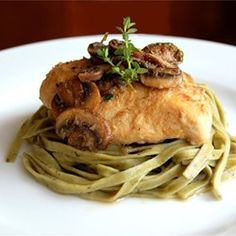 a white plate topped with pasta covered in meat and mushrooms on top of it's side