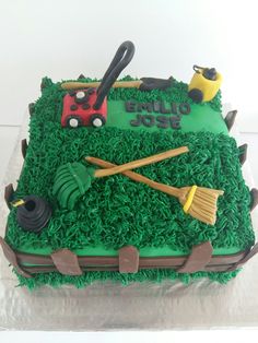 a birthday cake with green frosting and fondant decorations, including a lawnmower