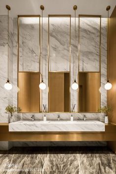 an elegant bathroom with marble counter tops and gold fixtures, along with two sinks in the center