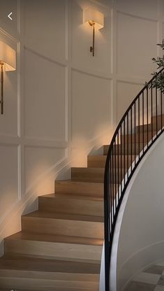 an elegant staircase with white walls and wooden steps