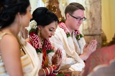 a man and woman sitting next to each other in front of a table with flowers on it