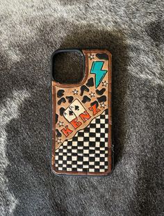 a cell phone case sitting on top of a gray carpet covered in black and white checkers