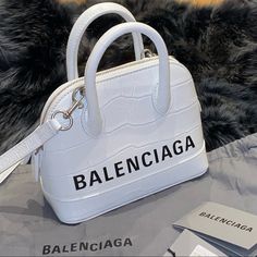 Balenciaga Ville Small Top Handle Bag In White Crocodile Embossed Calfskin Brand: Balenciaga Material: 100% Calfskin Leather Crocodile Embossed Calfskin Dimensions: W 7.4 Inches H 5.8 Inches D 2.3 Inches Description: Adjustable And Removable Shoulder Strap (54 Cm) Zipped Closure. Shiny Silver Hardware (Brass). Front Printed Logo Balenciaga Embossing Made In Italy Condition: Nwt Comes With A Balenciaga Dustbag Retail: $1,850.00 Relisted Was Away And Weren’t Able To Ship This Bag On Time Small Top Handle Bag, White Crocodile, White Balenciaga, Balenciaga Handbags, Football Game Outfit, Colorful Handbags, Balenciaga Women, Studded Bag, Balenciaga Black