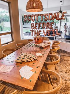 a wooden table topped with lots of pastries on top of a hard wood floor