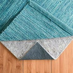 three different colors of rugs on a wooden floor