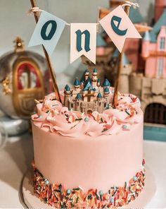 a birthday cake decorated with pink frosting and sprinkles