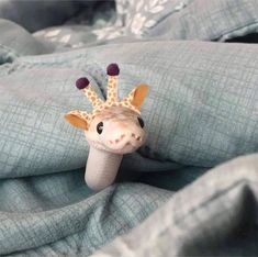 a stuffed giraffe laying on top of a blanket