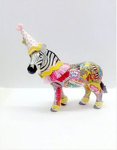 a toy zebra with a party hat on it's head is standing in front of a white background