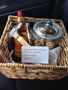 a wicker basket filled with condiments and personalized note sitting in the back seat of a car