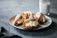 pastries on a plate next to a glass of milk