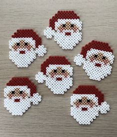 six pixelated santa claus coasters on a table