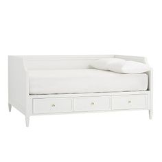 a white daybed with drawers underneath it and a pillow on the top of it