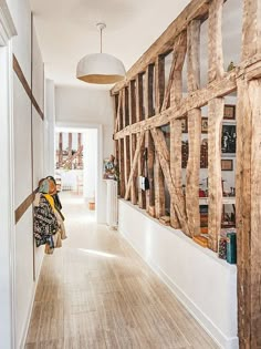 the hallway is lined with bookshelves made out of wooden planks and framed by white walls