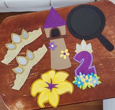 a wooden table topped with paper cut outs and flowers next to a pan on top of it