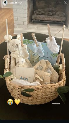 a basket filled with baby items sitting on top of a table next to a fireplace