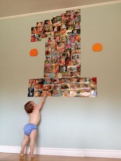 a little boy standing on top of a bed next to a wall covered in pictures