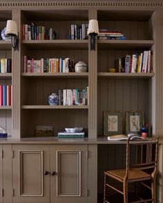 a room with bookshelves, chairs and a desk in front of the bookcases